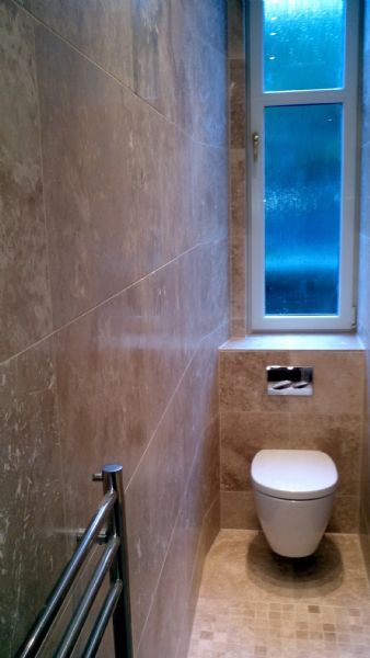Travertine tiles perfectly fitted, tenement bathroom with bespoke screen