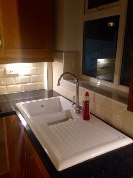 Ceramic sink installed in black gloss worktop