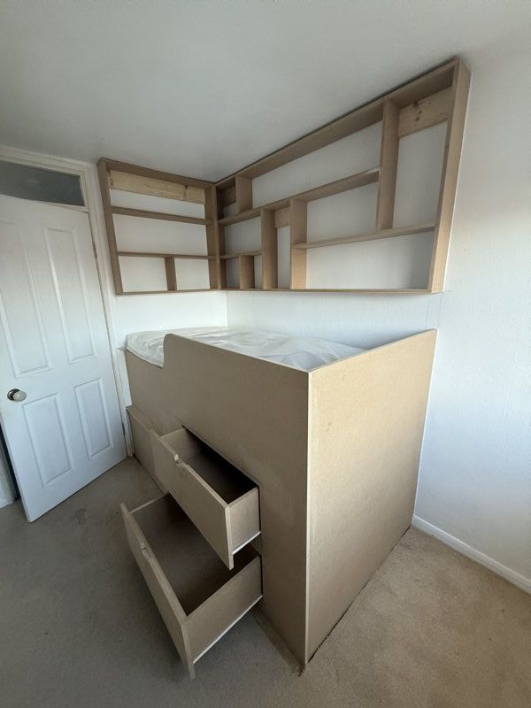 Bespoke bed built over the stair bulkhead to utilise the space and storage.
